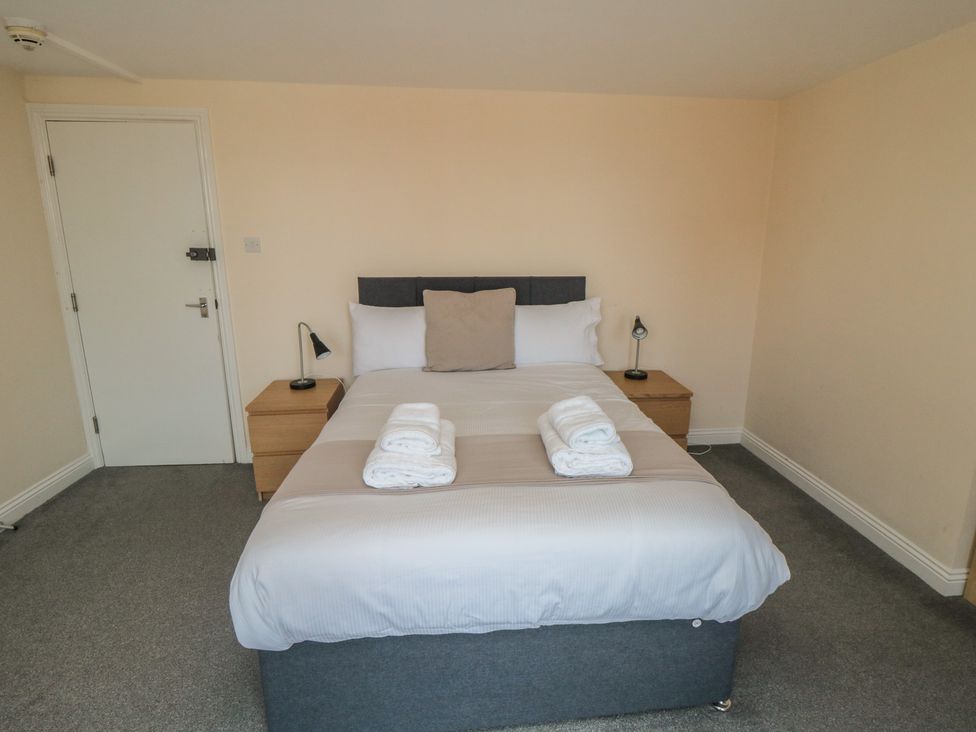A bedroom with a bed and bedside tables at The Newborough Apartment 4 in Scarborough