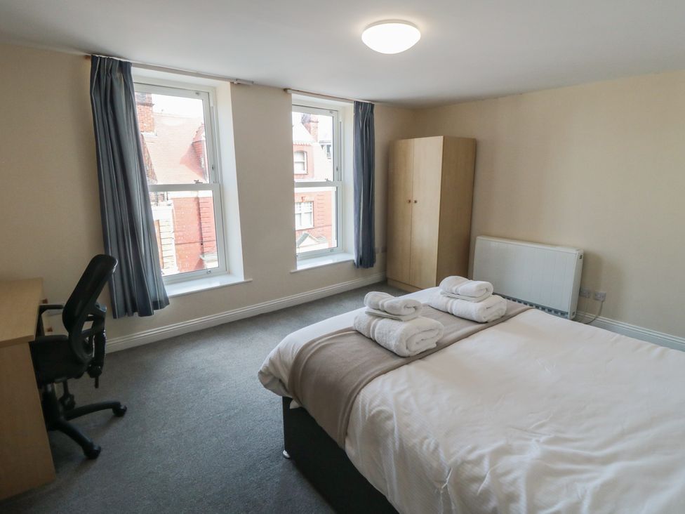 A bedroom with a bed and desk at The Newborough Apartment 4 Scarborough