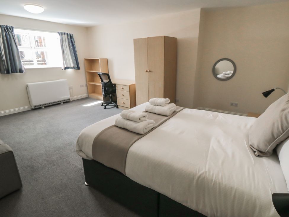 A bedroom with a bed and wardrobe at The Newborough Apartment 4 Scarborough
