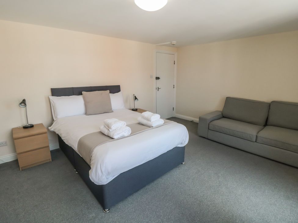 A bedroom with a bed and a couch at The Newborough Apartment 4 Scarborough
