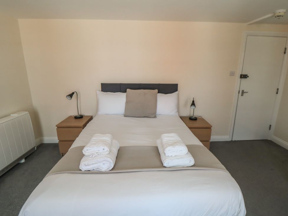 A bedroom with a bed and nightstands at The Newborough Apartment 4 Scarborough