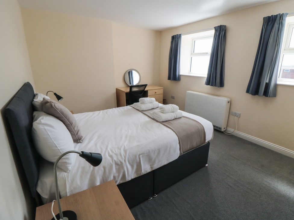 A bedroom with a bed and desk at The Newborough Apartment 4 Scarborough