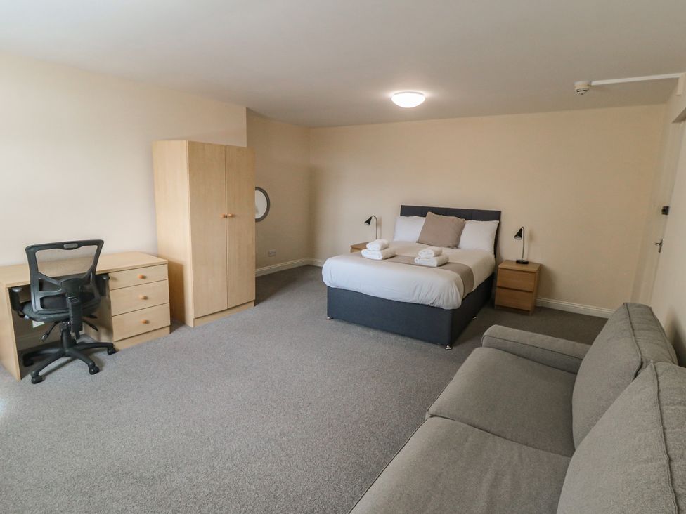 A bedroom with a bed, desk and sofa at The Newborough Apartment 4 Scarborough