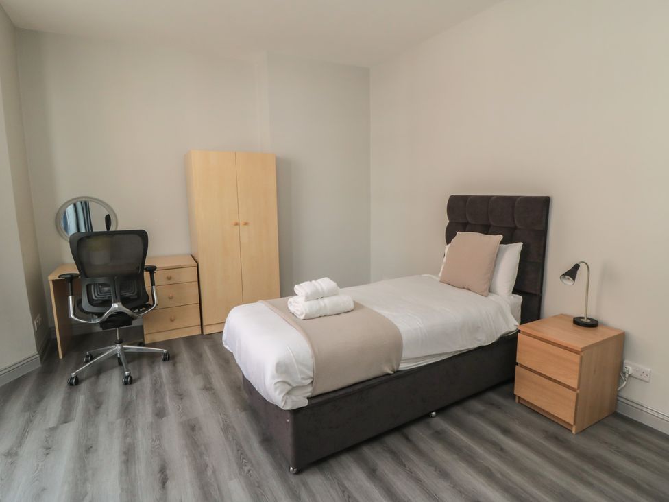 A bedroom with a bed and desk at The Newborough Apartment 2 Scarborough