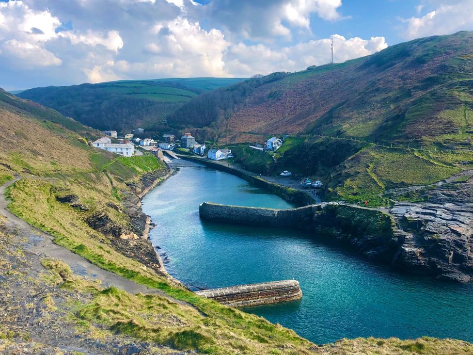 A coastal scene with water and hills at Puffin Cottage in Tintagel