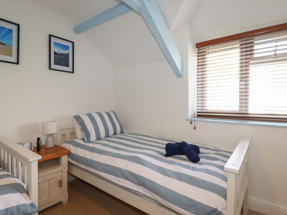 A bedroom with two single beds and a bedside table at Puffin Cottage in Tintagel