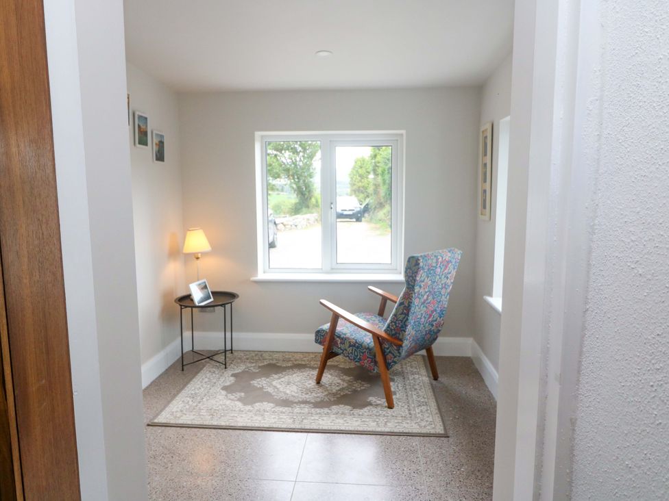 A snug area with a chair, table, and lamp at Valley View House in Kealkill, County Cork