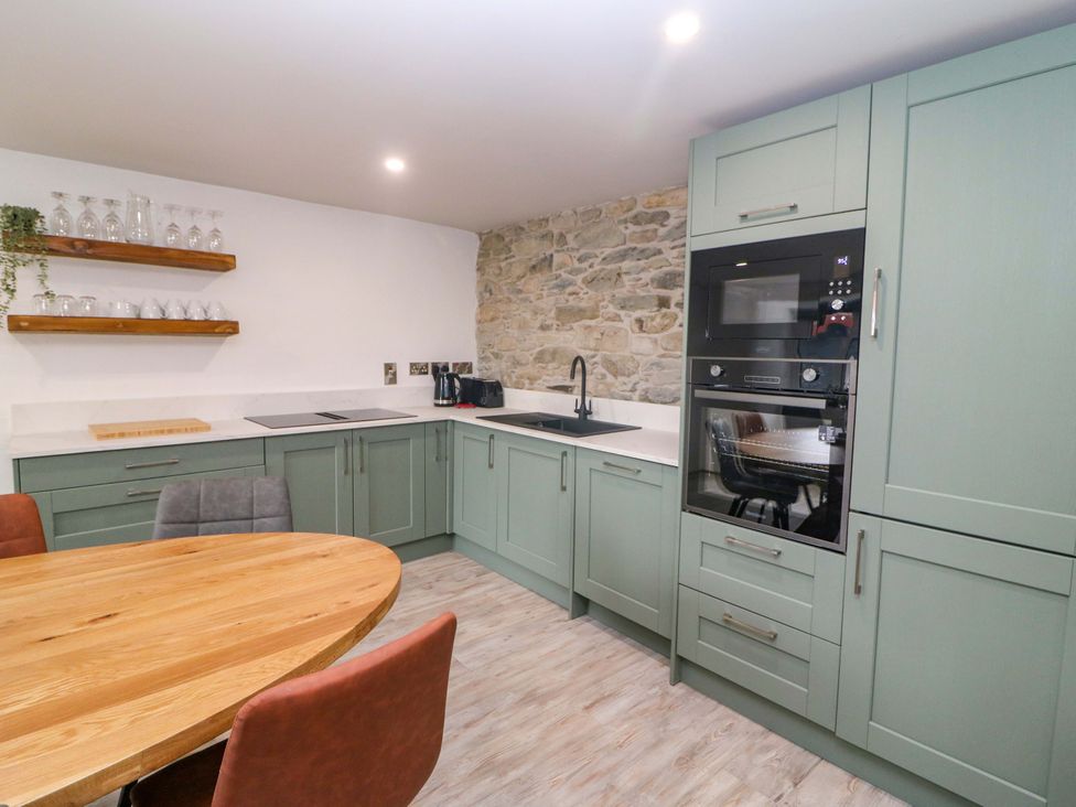 A kitchen with cabinets, sink, and dining table at Valley View House in Kealkill, County Cork