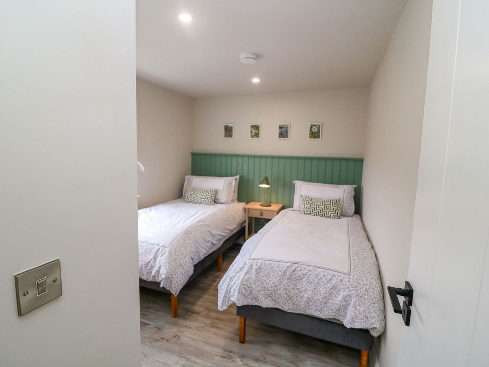 A bedroom with two beds and a nightstand at Valley View House, Kealkill, County Cork