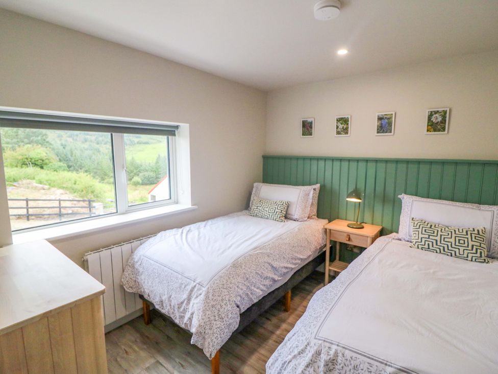 A bedroom with two beds and a window at Valley View House in Kealkill, County Cork