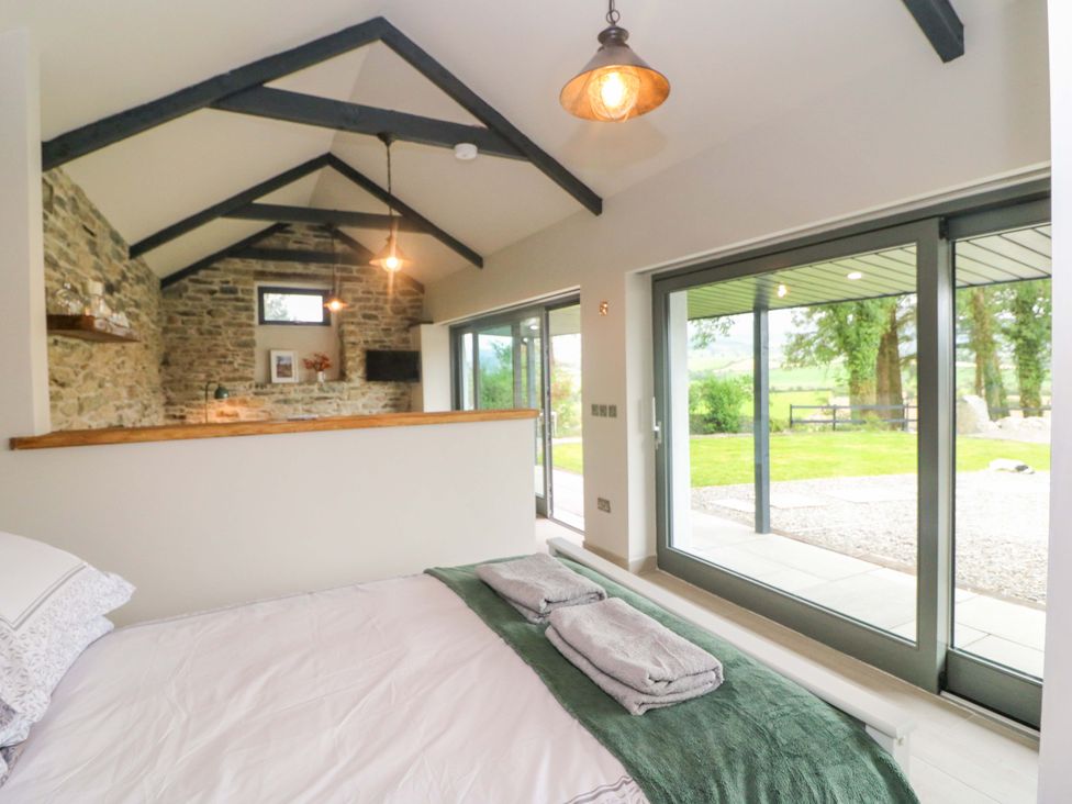 A bedroom featuring a bed with towels and large windows at The Stall near Kealkill, County Cork