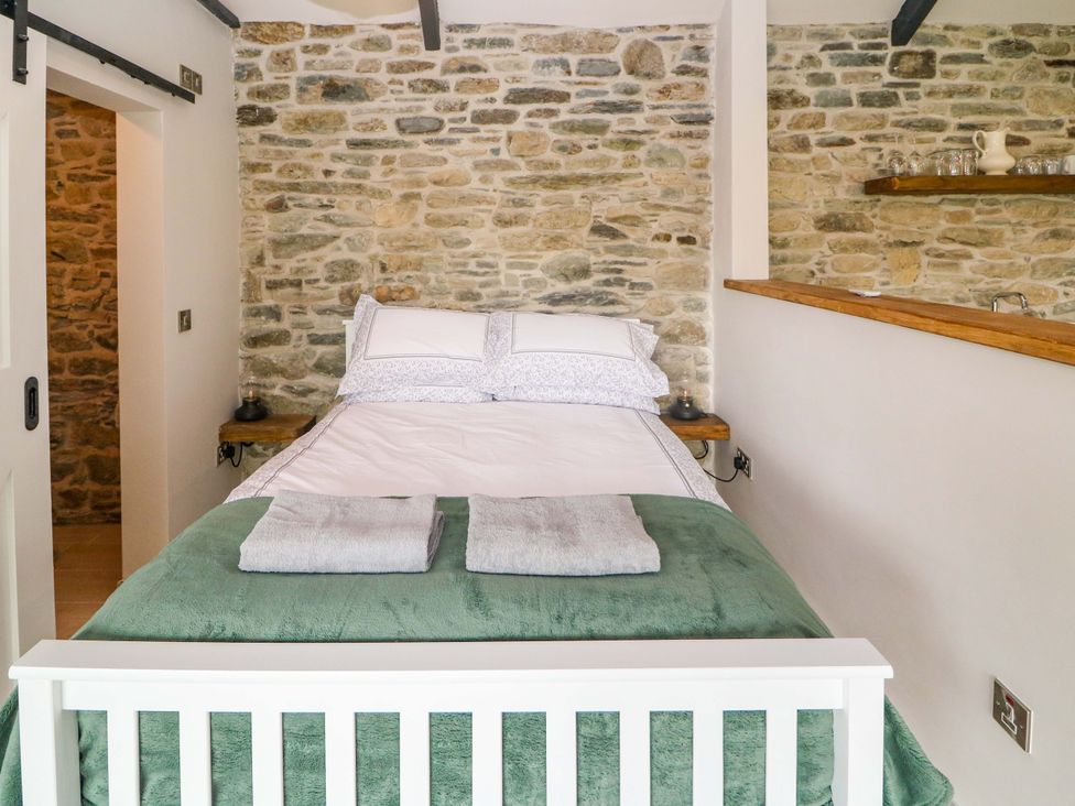 A bedroom with a bed and shelves at The Stall near Kealkill, County Cork