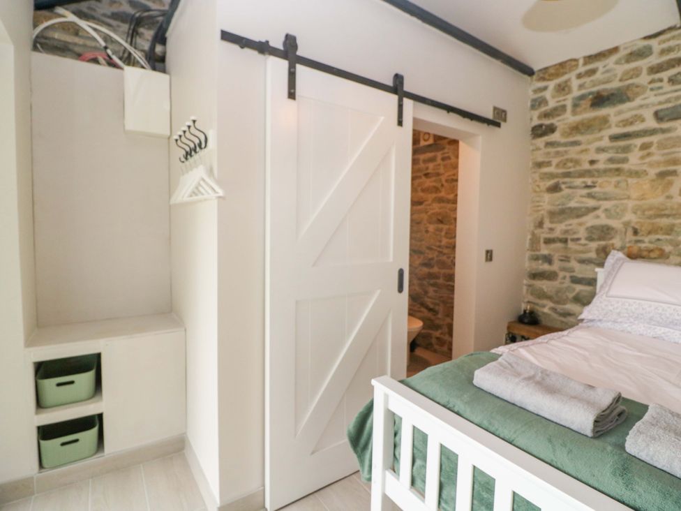 A bedroom with a bed and sliding door at The Stall near Kealkill, County Cork