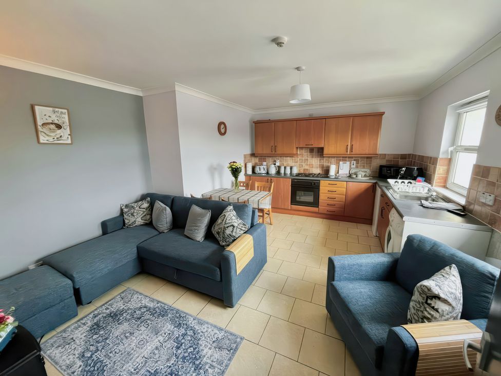 A kitchen with a dining table and sofa at Shalom Apartment 98B Markethill