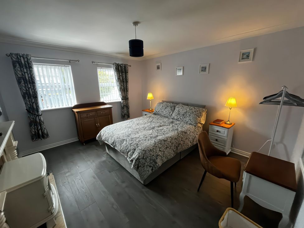 A bedroom with a bed and two lamps at Shalom Apartment 98B Markethill