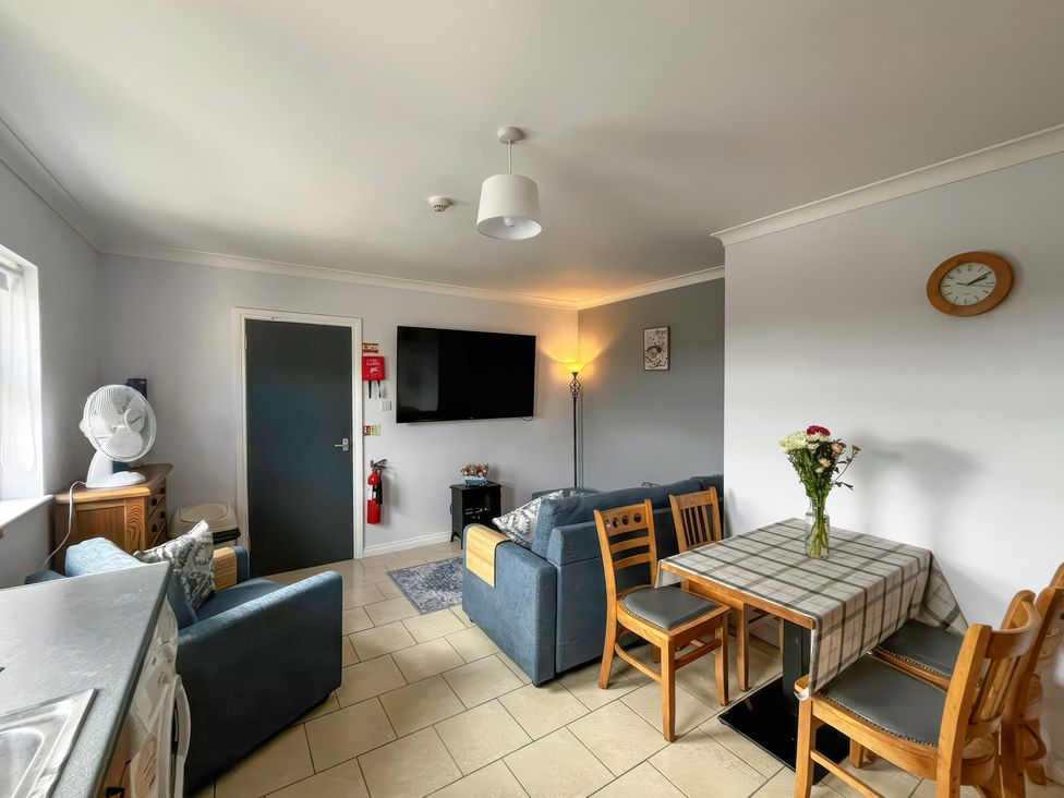 A living room with a sofa and a dining table at Shalom Apartment 98B Markethill