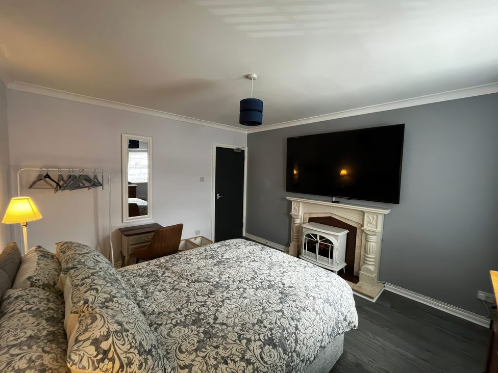 A bedroom with a bed and television at Shalom Apartment 98B Markethill
