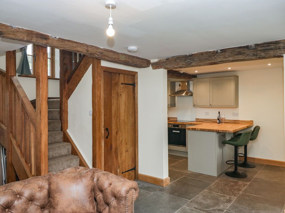 A kitchen with stairs and bar stools at Howgill Head in Kendal