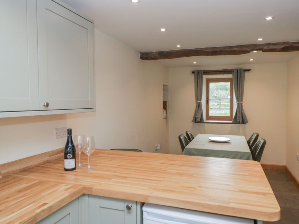 A kitchen with cabinets and dining setup at Howgill Head in Kendal