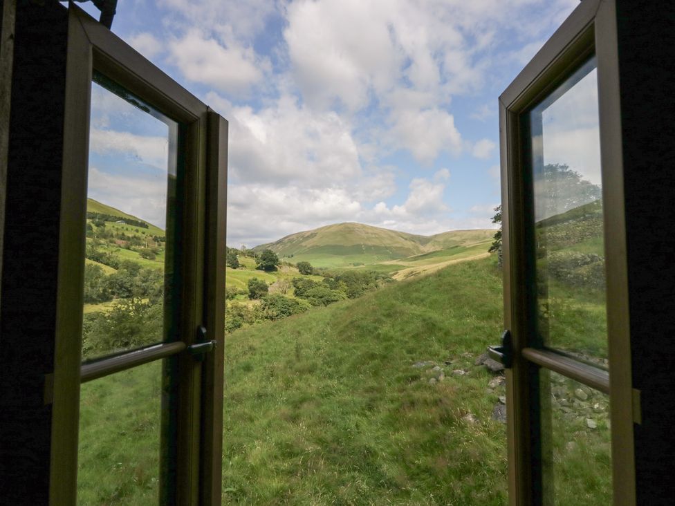 A view from a window showing mountains and grass at Howgill Head in Kendal