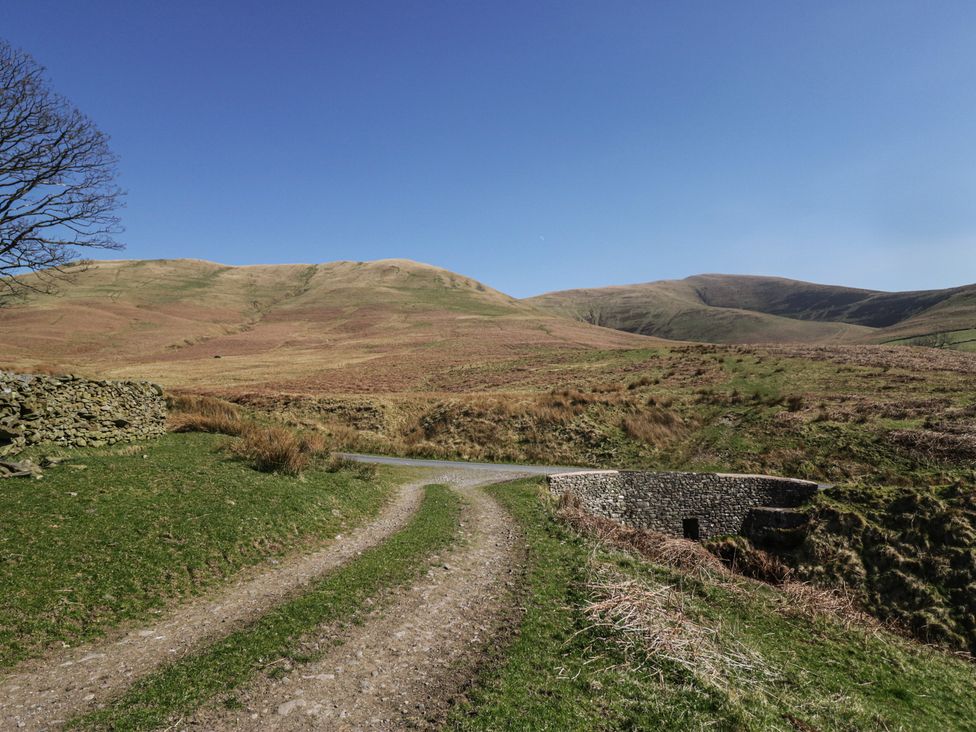A dirt path leading through hills at Howgill Head in Kendal