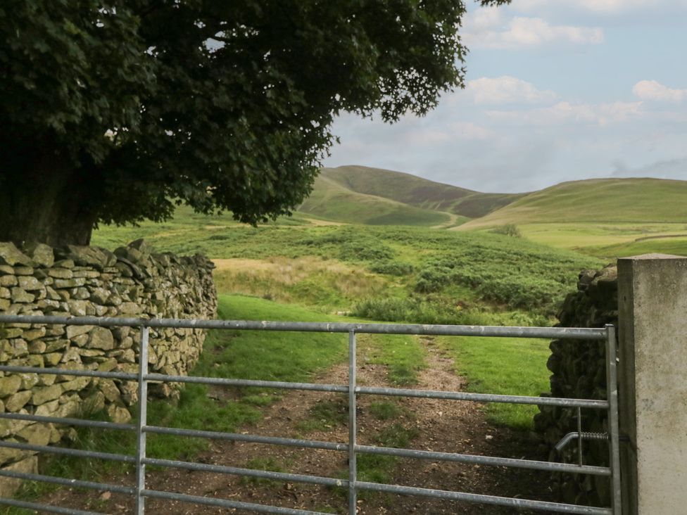 A gate opening to a pathway leading to hills at Howgill Head in Kendal