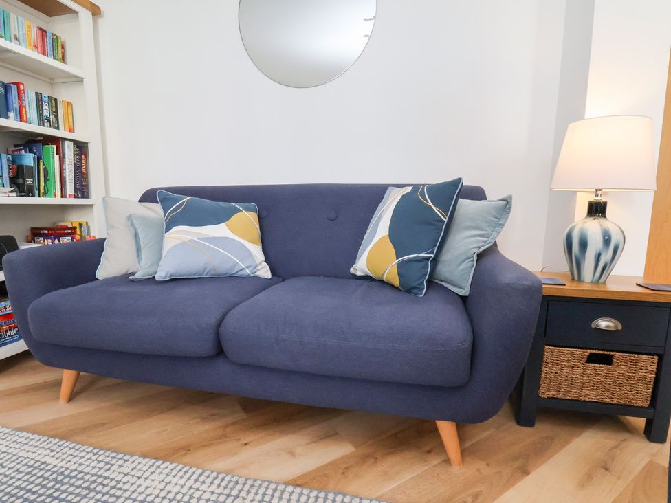A living room with a sofa and bookshelf at Belle's View in Scarborough
