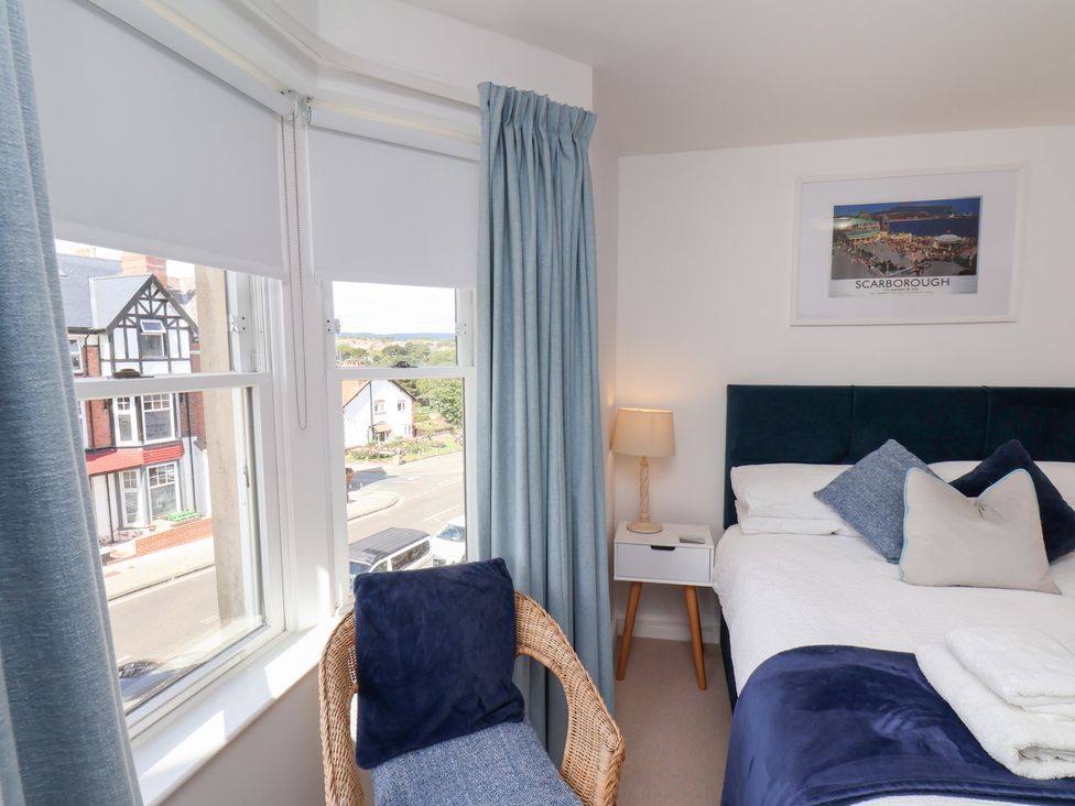 A bedroom with a bed and windows at Belle's View in Scarborough