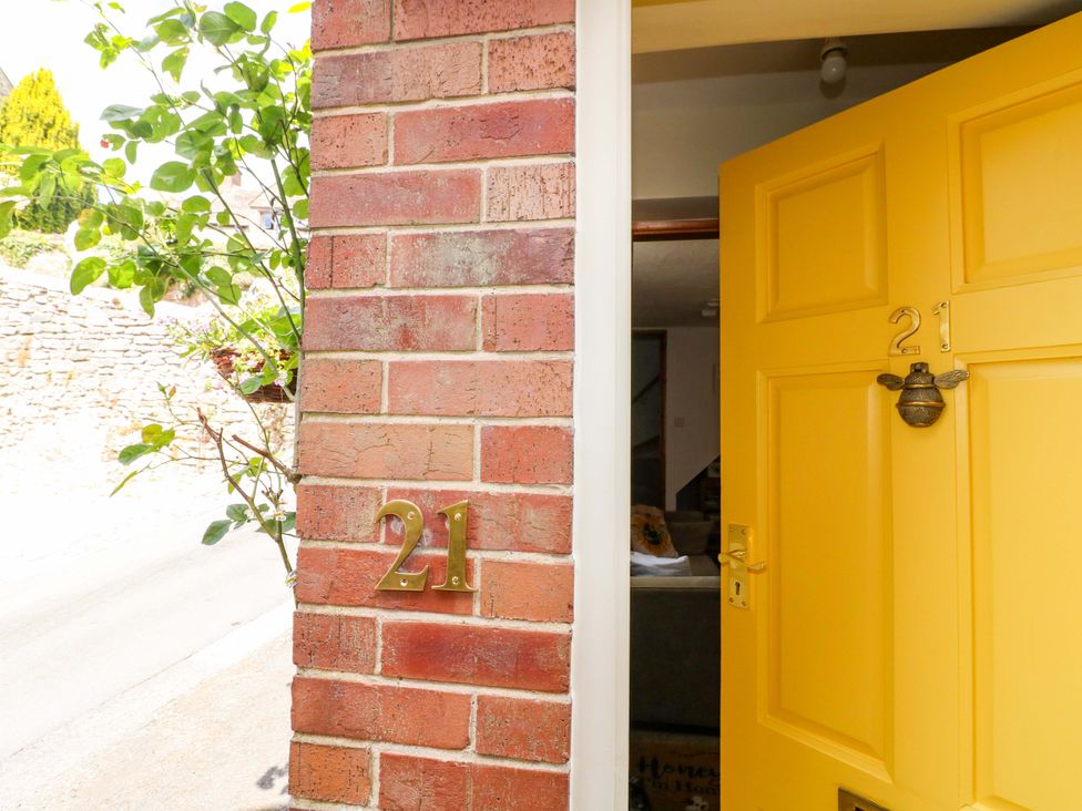 An entrance with a yellow door and brick wall at The Beehive in Wirksworth