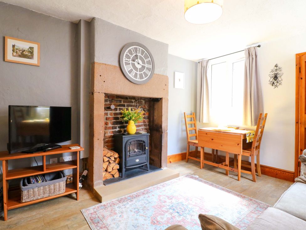 A living room with a fireplace and television at The Beehive in Wirksworth