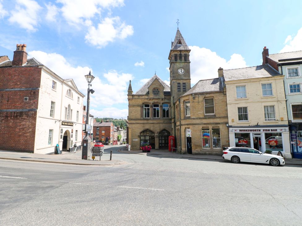 A street view with a clock tower and shops at The Beehive in Wirksworth