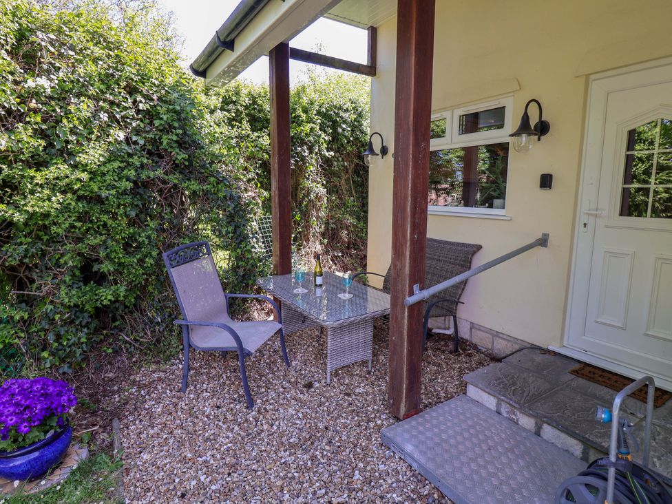 A table and chairs on a patio at Rosemarie Annexe in Axminster