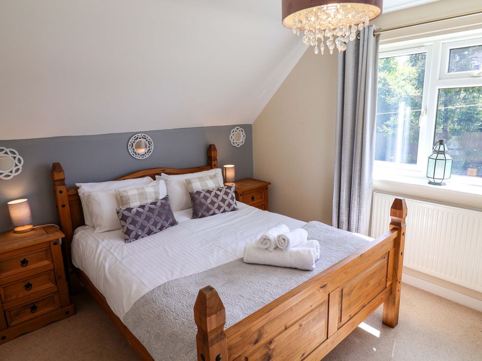 A bedroom with a wooden bed and nightstands at Rosemarie Annexe in Axminster