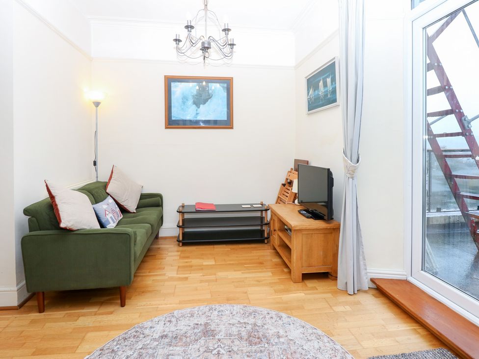 A living room with a sofa and television at Captain’s Quarters in Porthmadog