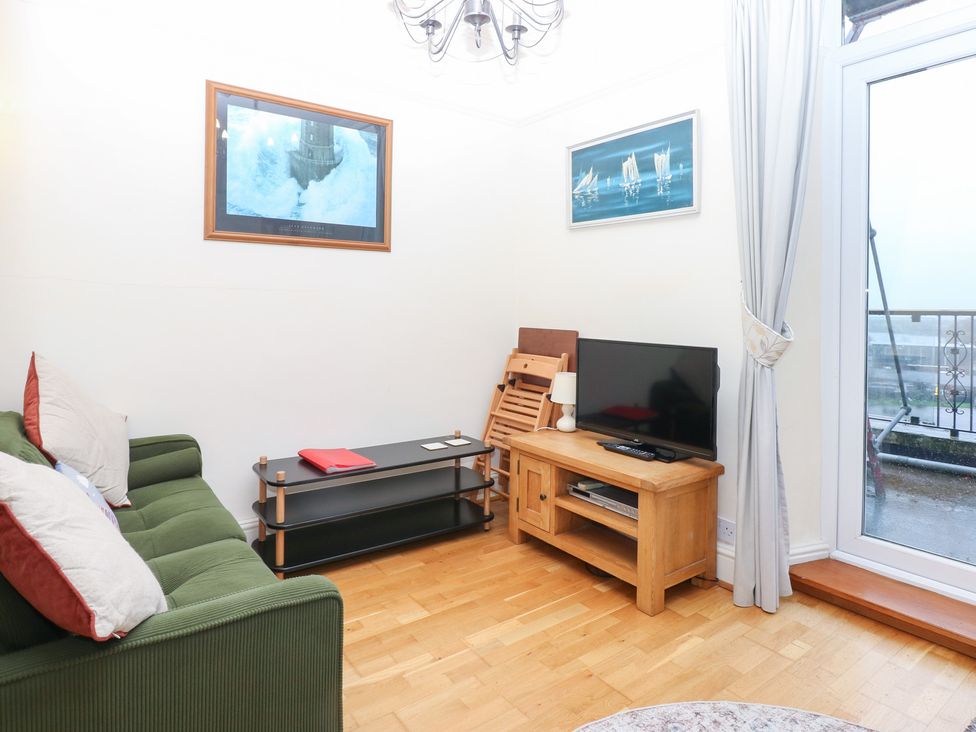 A living room with a sofa and television at Captain’s Quarters Porthmadog