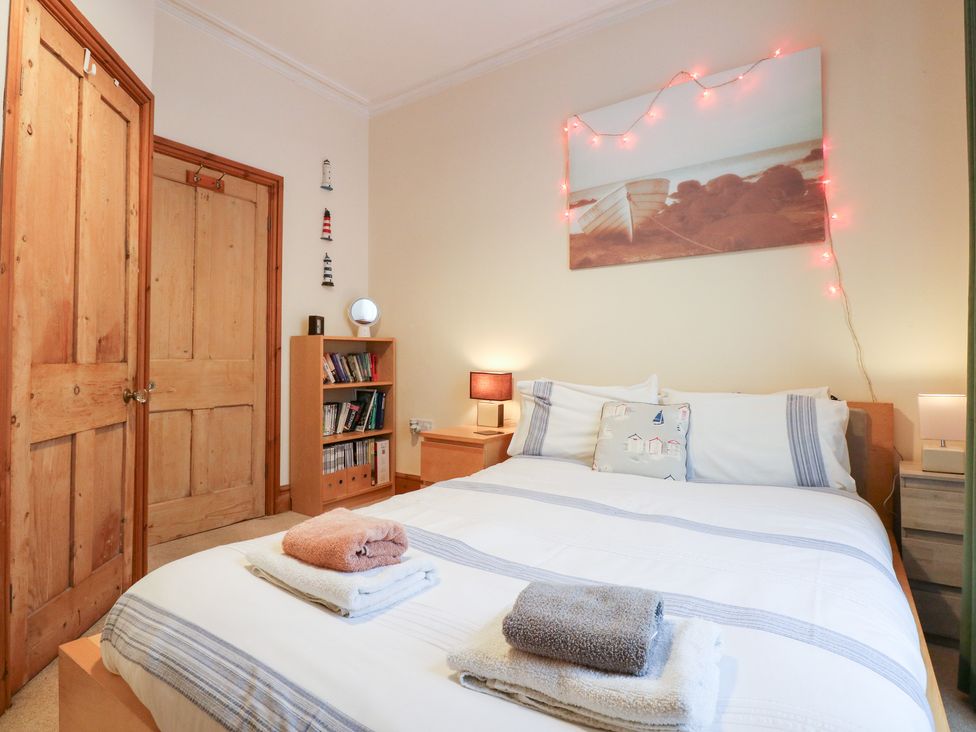 A bedroom with a bed and bedside tables at Captain’s Quarters in Porthmadog