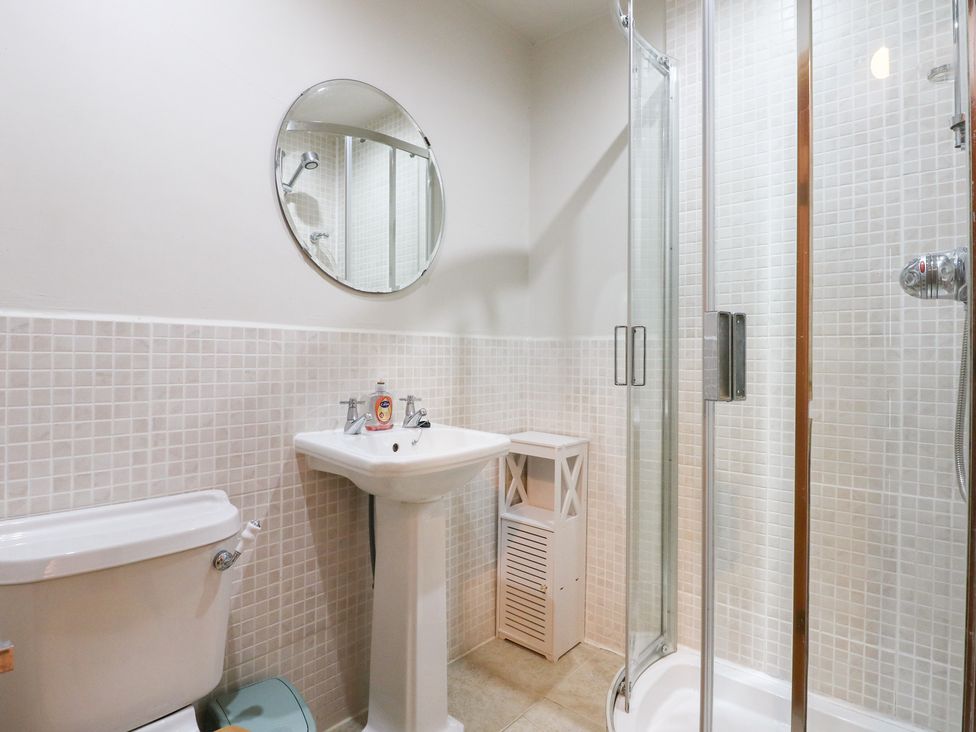 A bathroom with shower, sink, and toilet at Captain’s Quarters in Porthmadog