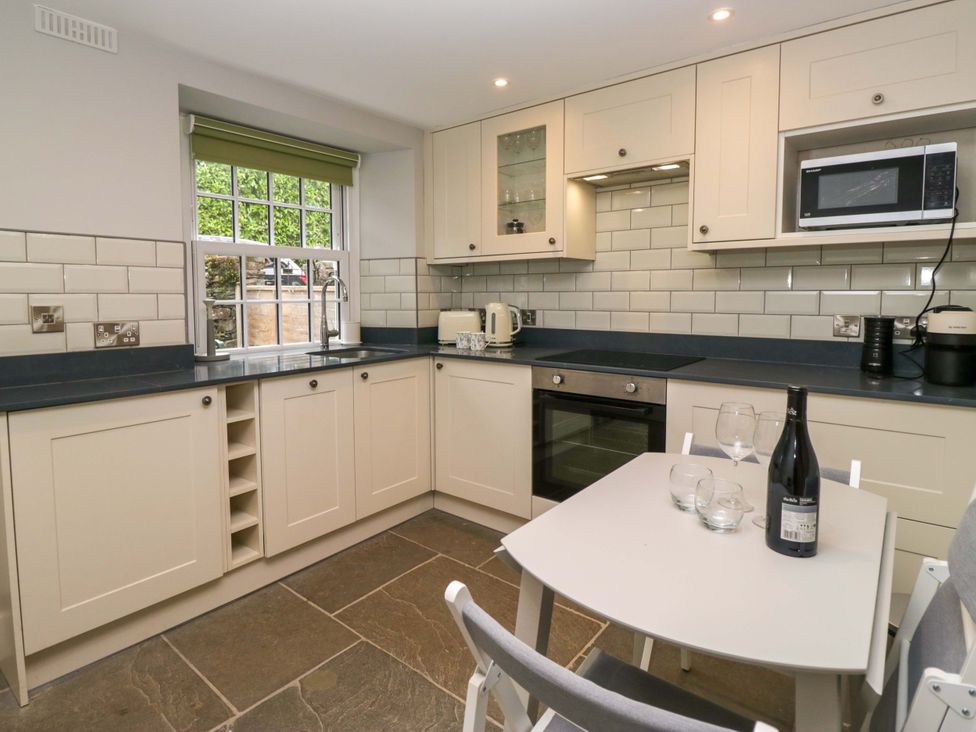 A kitchen with cabinets and appliances at Dove Cottage in Ambleside