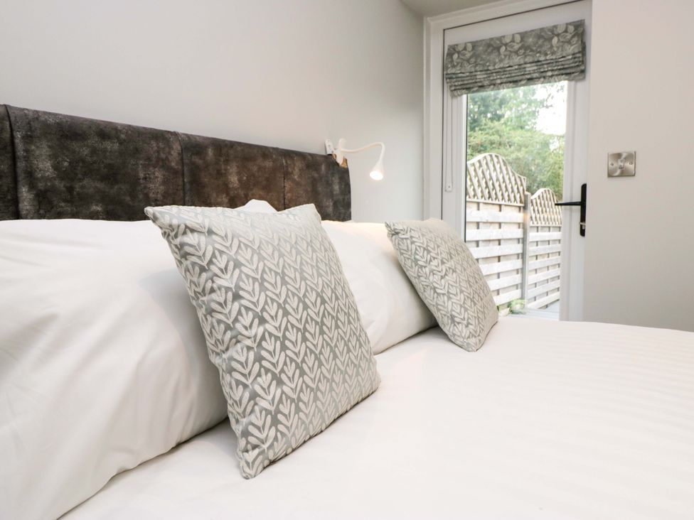 A bed with pillows and a window in a bedroom at Dove Cottage in Ambleside