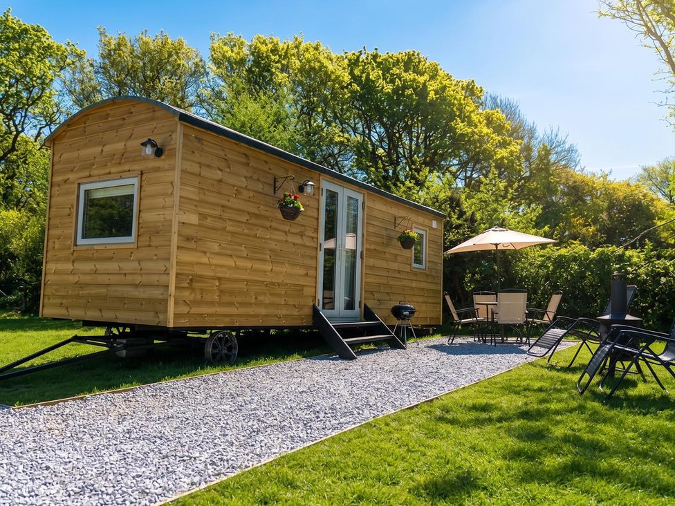 A tiny house with outdoor seating and a grill at Buzzards Lodge near Victoria