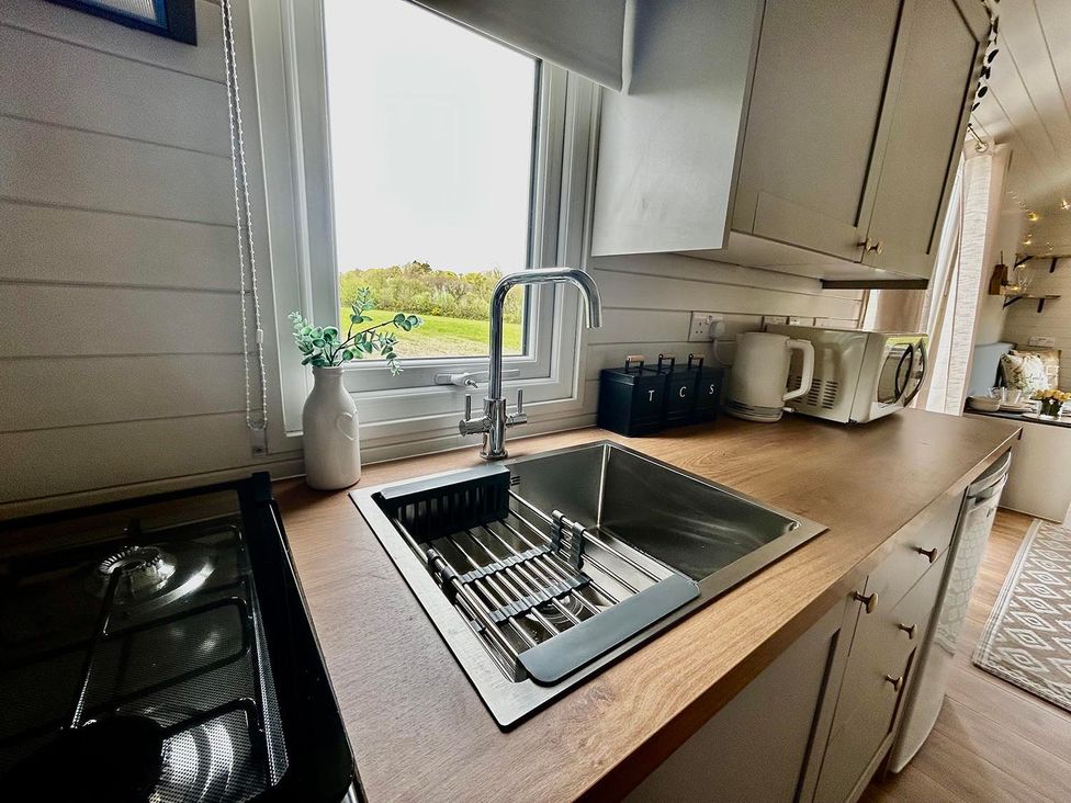 A kitchen with a sink and stove at Buzzards Lodge near Victoria