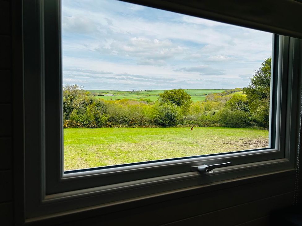 A view from a window showing grass and hills at Buzzards Lodge near Victoria