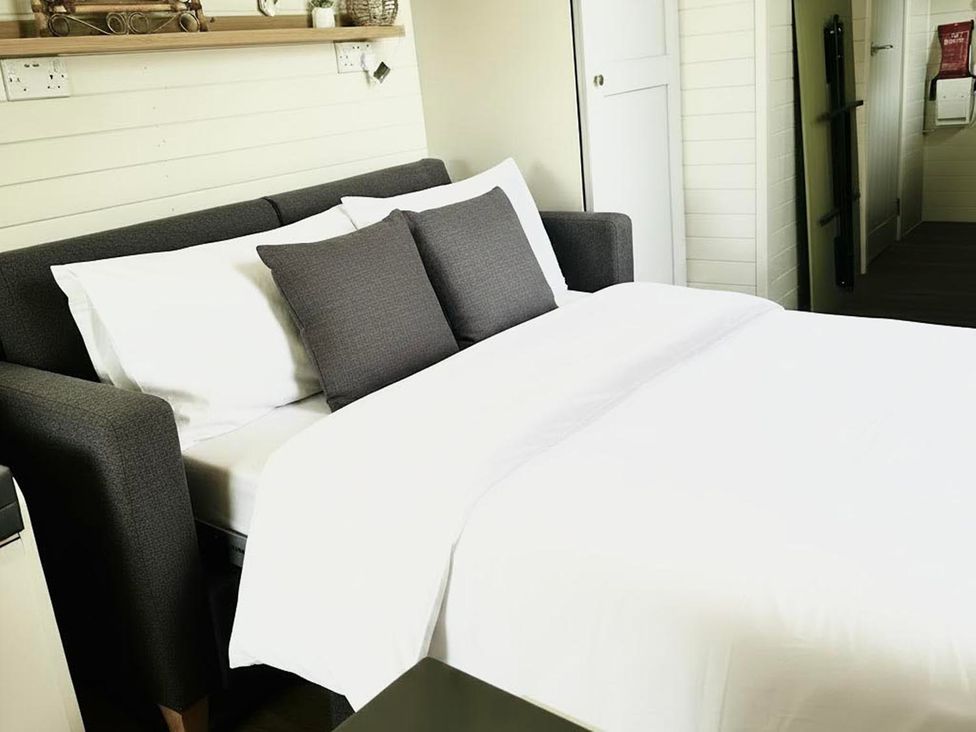 A bed with pillows and a shelf at Buzzards Lodge near Victoria