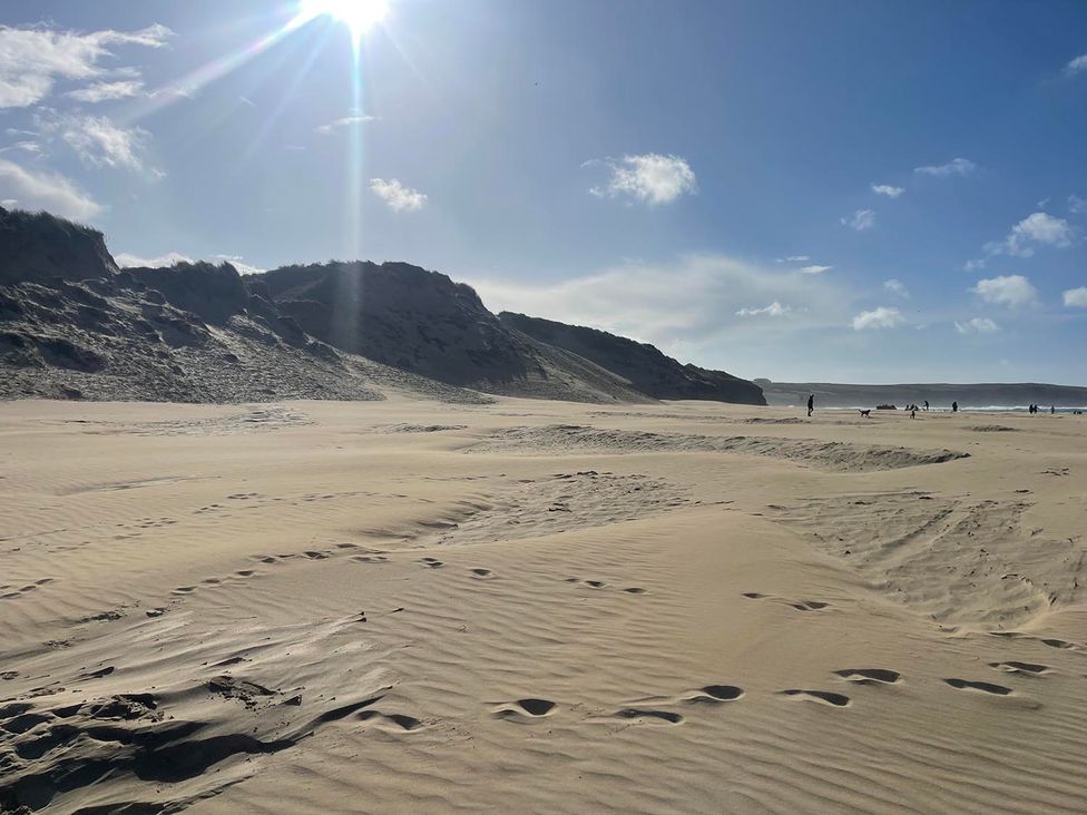 A beach with sand dunes and people in the distance at Buzzards Lodge near Victoria