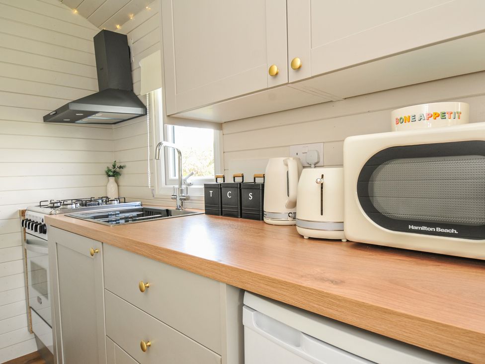 A kitchen with a stove and microwave at Buzzards Lodge in Roche