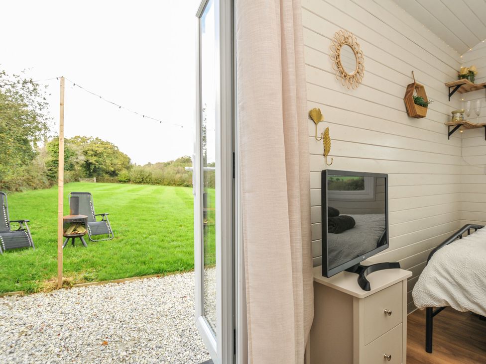 A bedroom with a television and bed at Buzzards Lodge in Roche