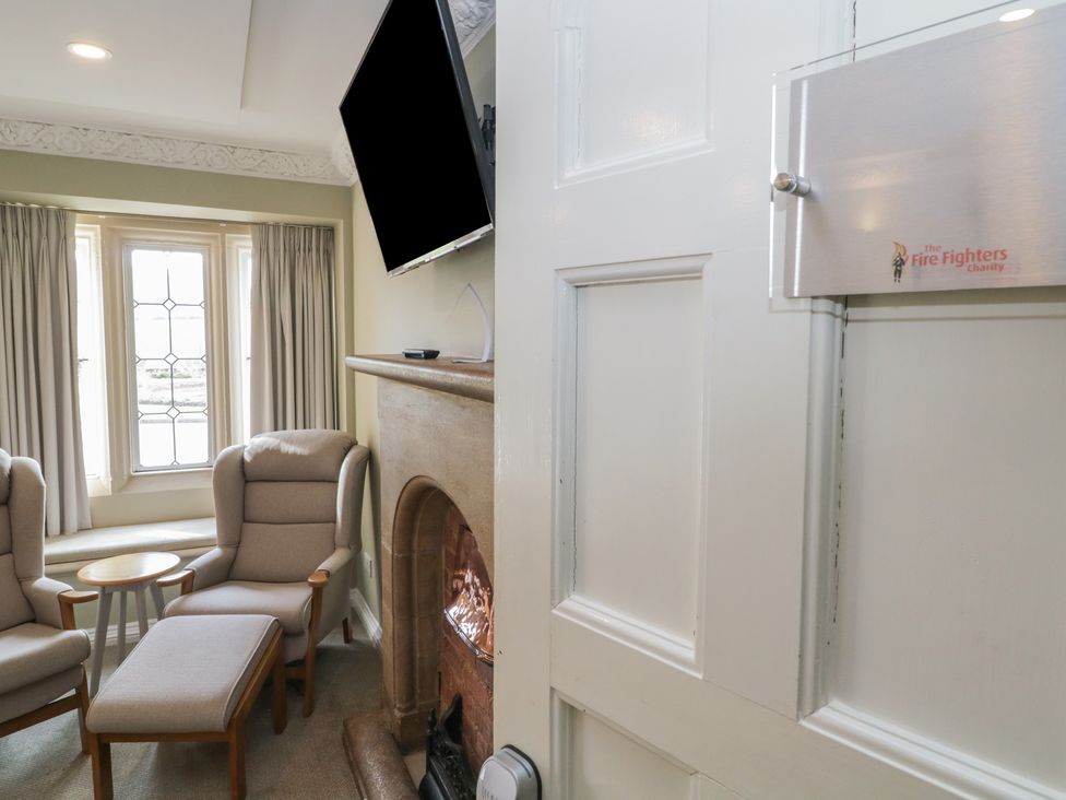 A sitting room with two chairs and a television at The Babbling Brook Nook in Chudleigh