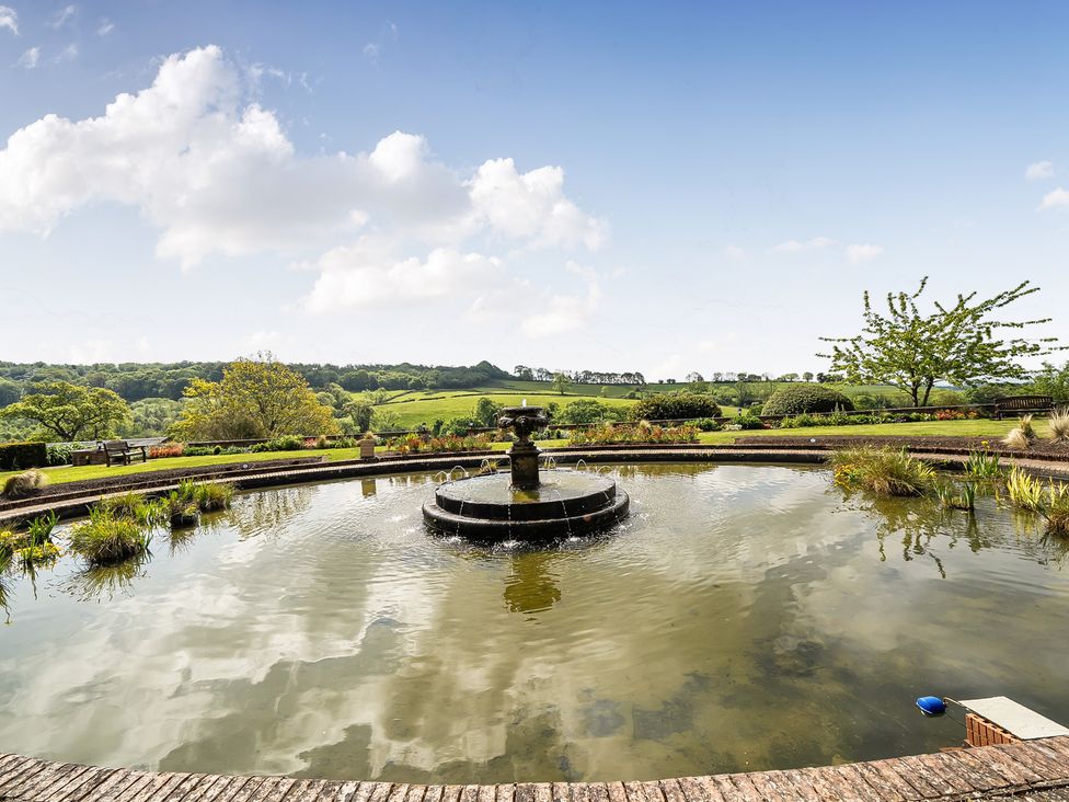 A pond with a fountain and benches at Harcombe House Rooms Accessible Ground Floor Twin Chudleigh