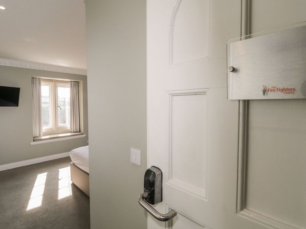 A bedroom with a door and window at Harcombe Heights in Chudleigh