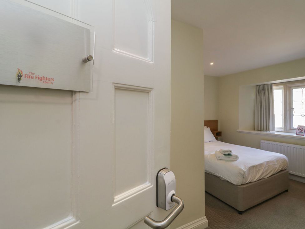 A bedroom with a bed and window at The Treetop Nook in Chudleigh